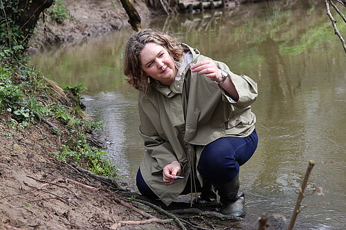 Anna testing water in river Frome 