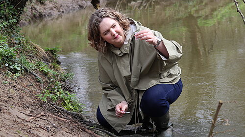 Anna testing water in river Frome 